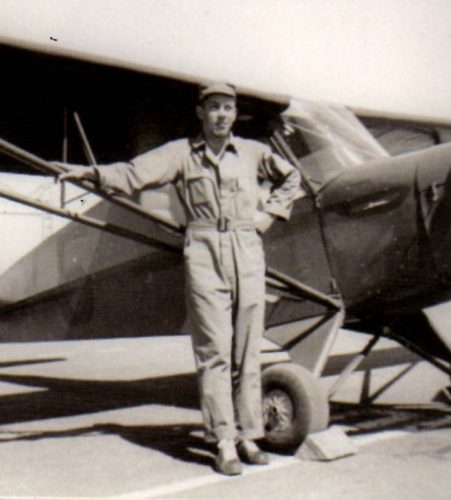 Gil Deibel posing next to a B-24 bomber